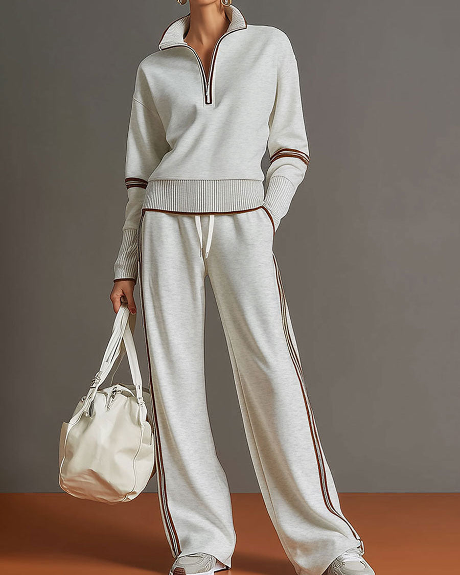 Sudadera gris y blanca de media cremallera con estilo vintage, acompañada de pantalones amplios