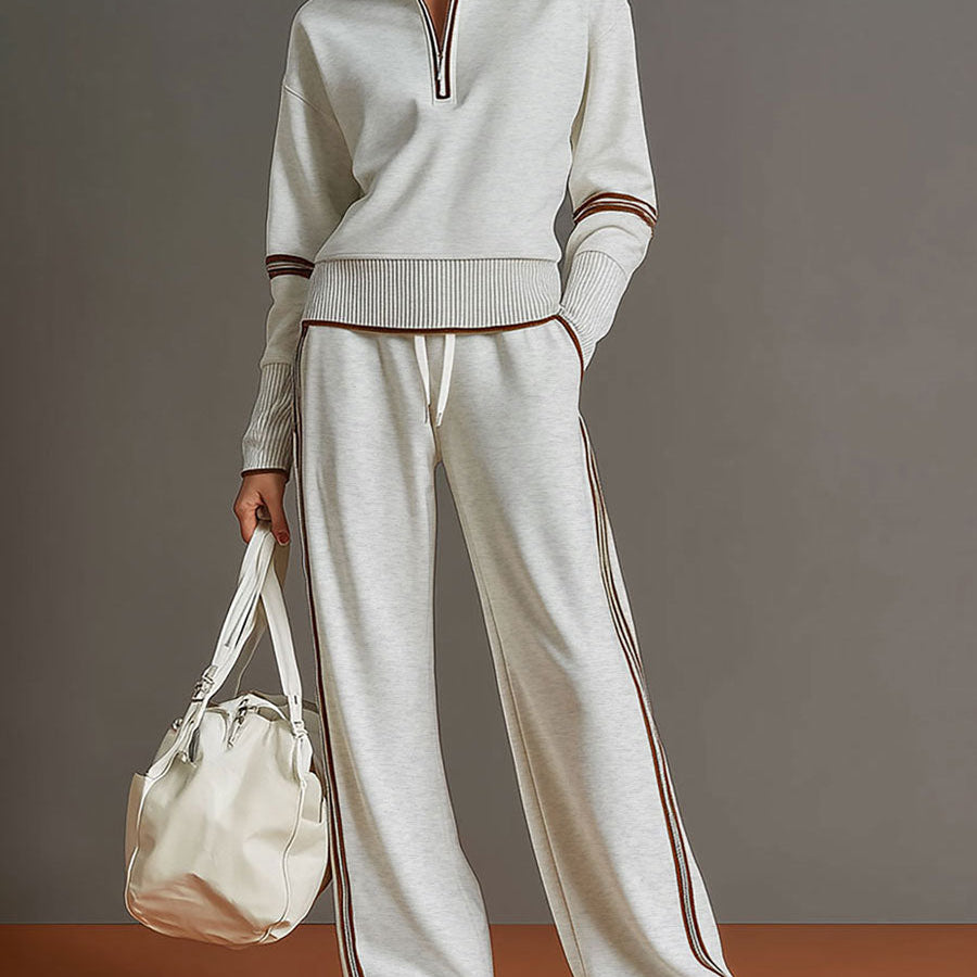 Sudadera gris y blanca de media cremallera con estilo vintage, acompañada de pantalones amplios
