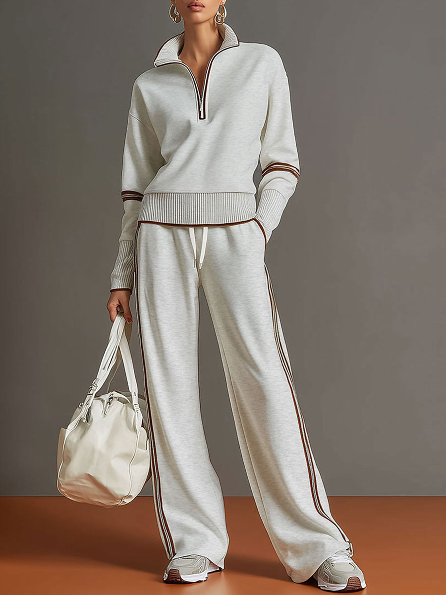 Sudadera gris y blanca de media cremallera con estilo vintage, acompañada de pantalones amplios