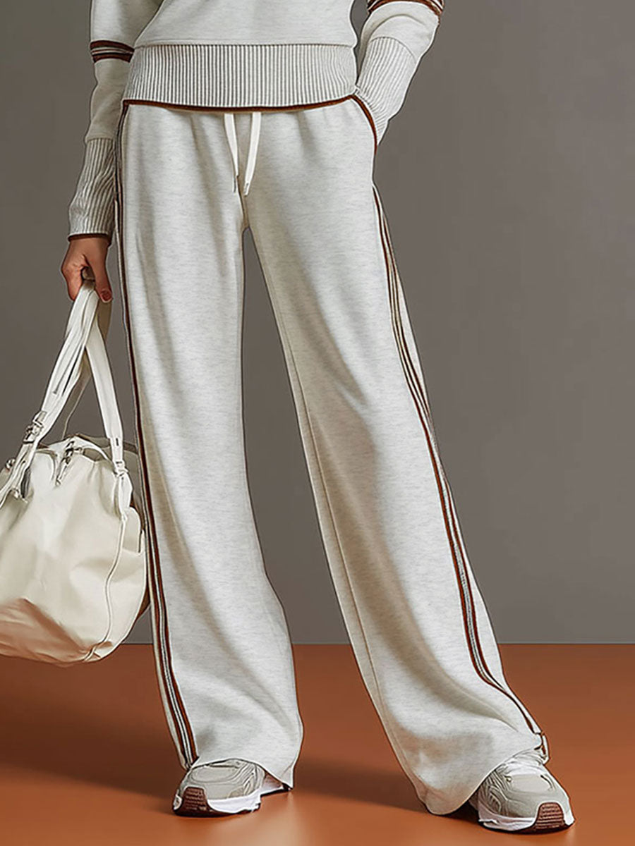 Sudadera gris y blanca de media cremallera con estilo vintage, acompañada de pantalones amplios