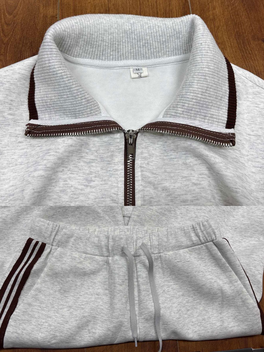 Sudadera gris y blanca de media cremallera con estilo vintage, acompañada de pantalones amplios