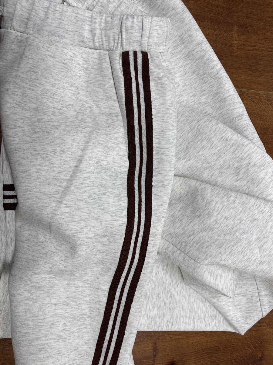 Sudadera gris y blanca de media cremallera con estilo vintage, acompañada de pantalones amplios