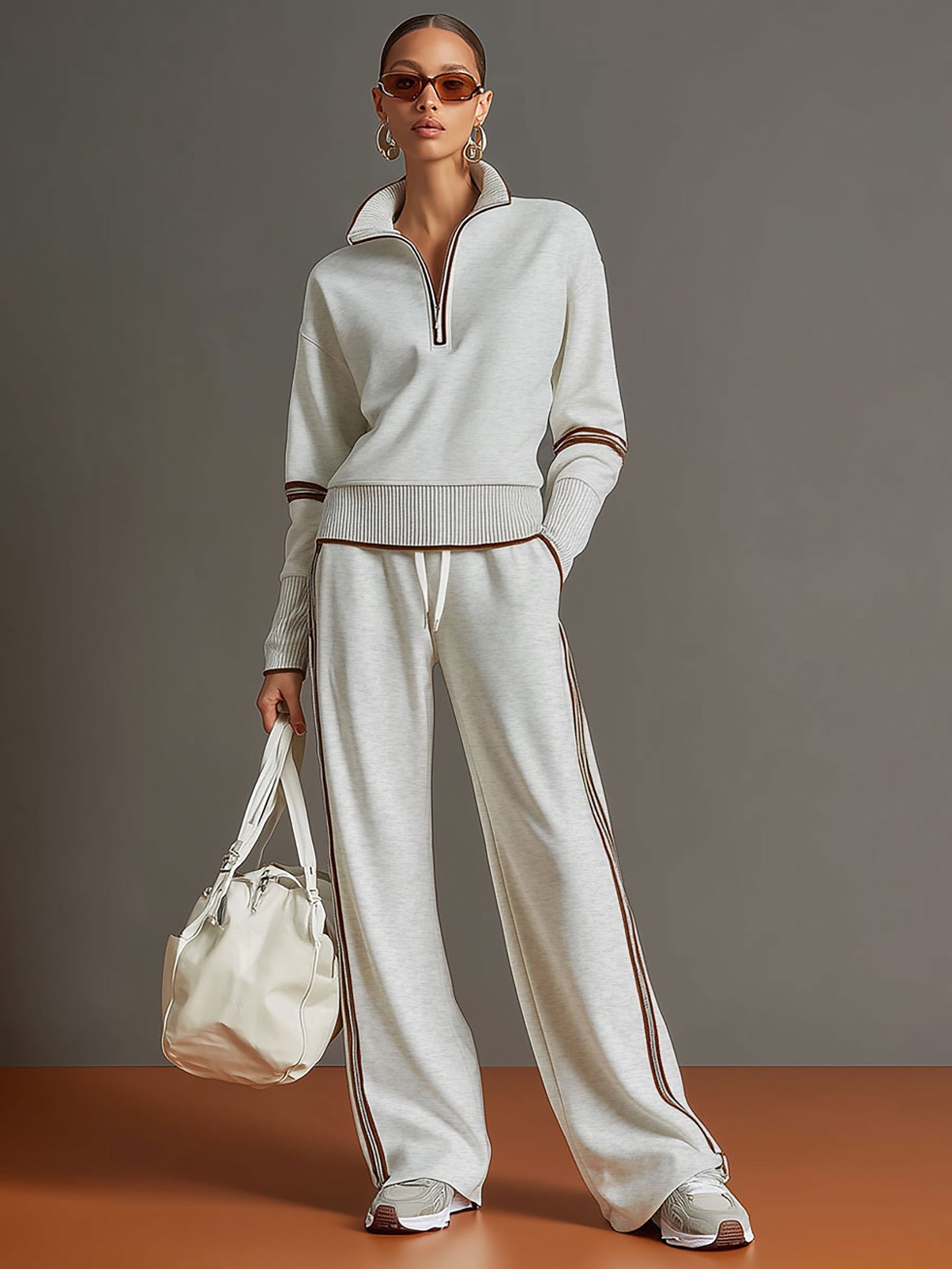 Sudadera gris y blanca de media cremallera con estilo vintage, acompañada de pantalones amplios